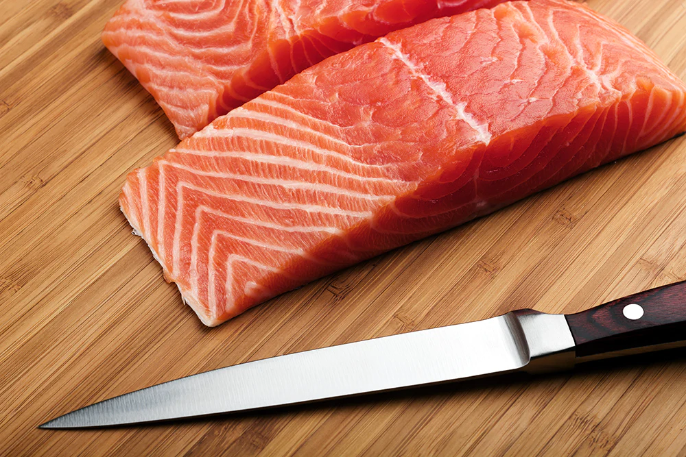 slice of salmon and best fillet knife beside it. 